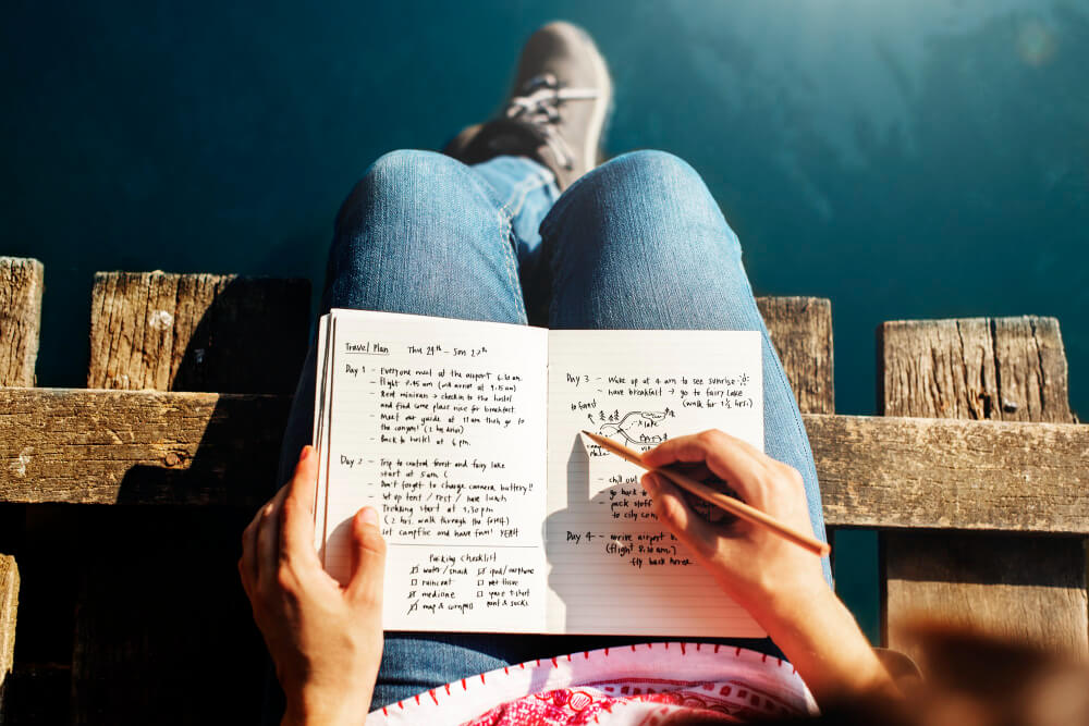 Woman journaling in a notebook during a quiet self-reflection session at home